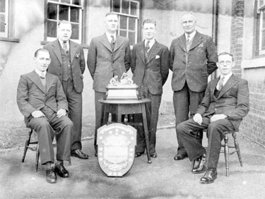 Gaskell Deacons First Aid Team with trophies outside the ICI Recreation Club, Liverpool Road. Seated on the left is Mr S Bradshaw and standing third from left is Mr Jack Parker.